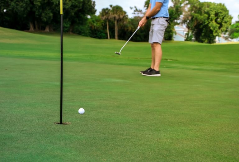 A golfer putting on a rolling green golf course