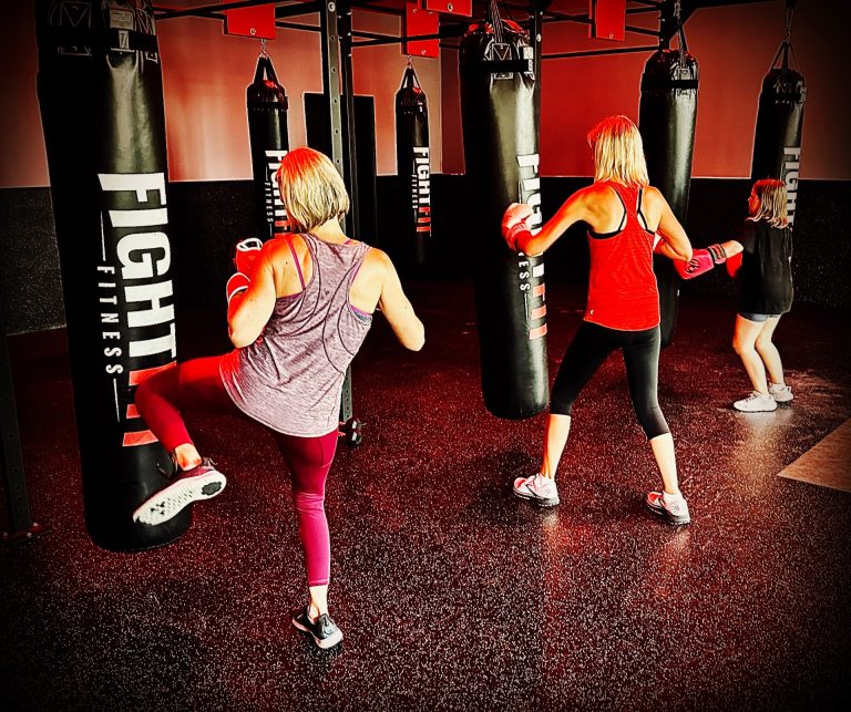 Women kickboxing with heavy bags at FightFit Fitness Rock Hills top kickboxing gym. Powerful workout session 768x643