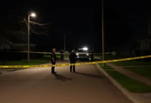 Police officers investigating a car at a crime scene.