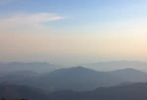 Hazy sky over mountains indicating air pollution from wildfires