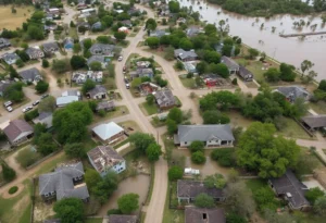 Overview of a flooded area in Texas Hill Country with submerged homes and debris.
