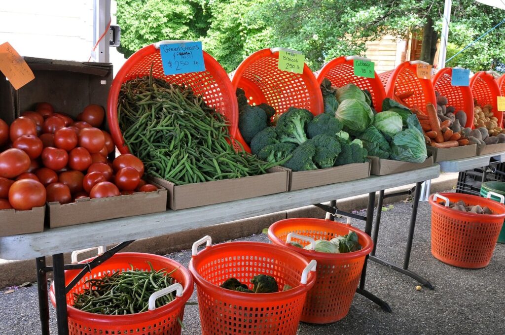 Fresh produce in baskets at a farmers market stand