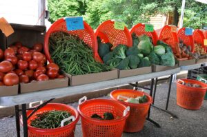 Fresh produce in baskets at a farmers market stand