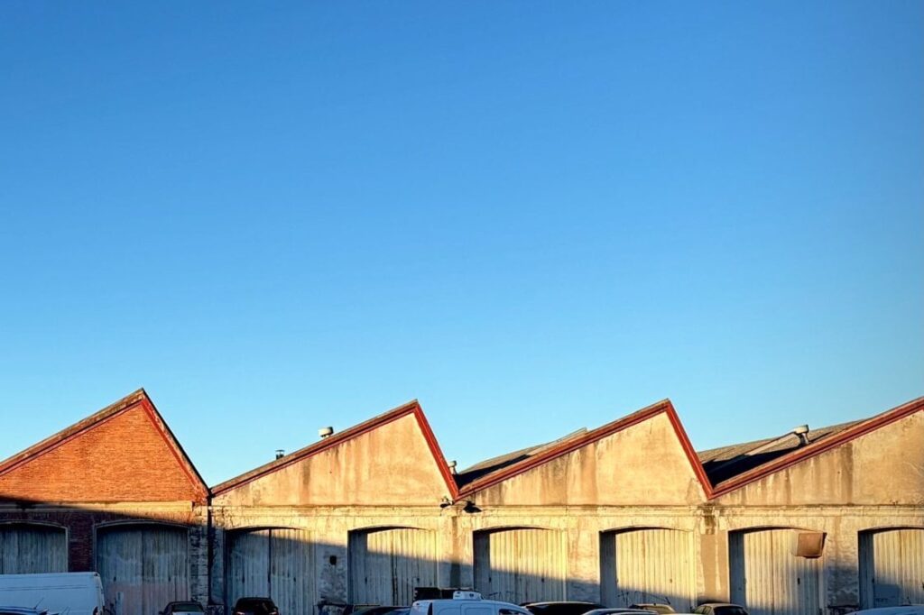 Row of industrial warehouse buildings with red roofs